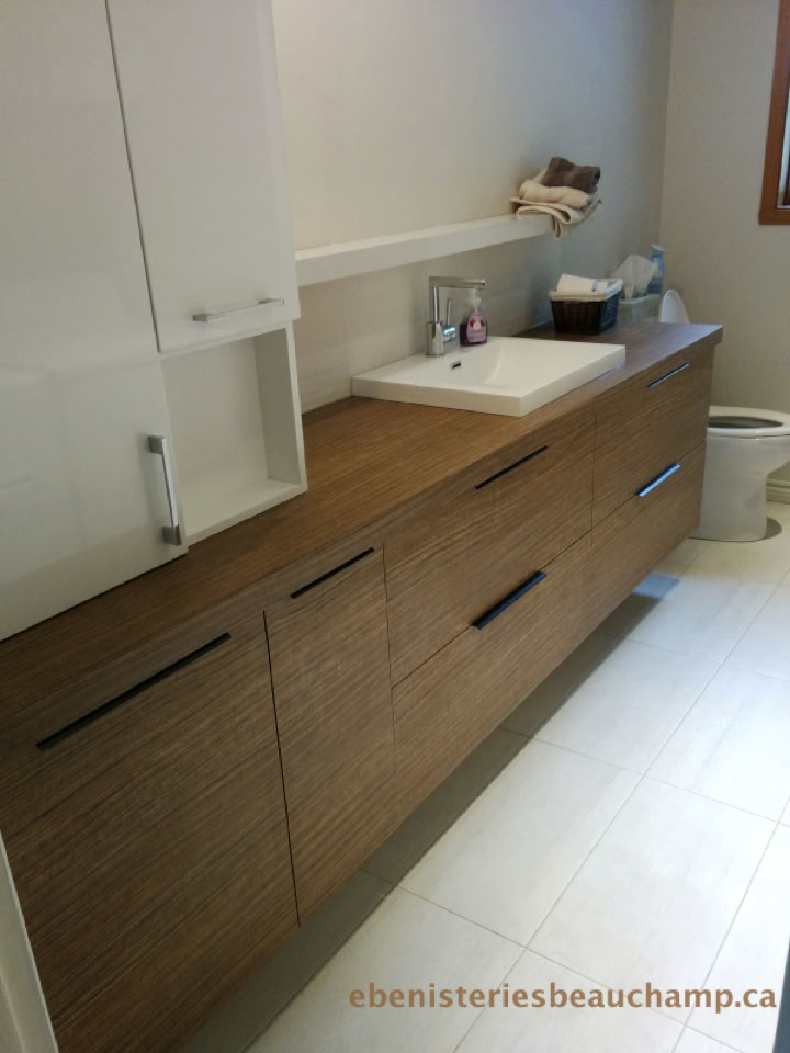 Meuble de salle de bain en bois avec un évier blanc, miroir, et divers articles de toilette sur le comptoir.