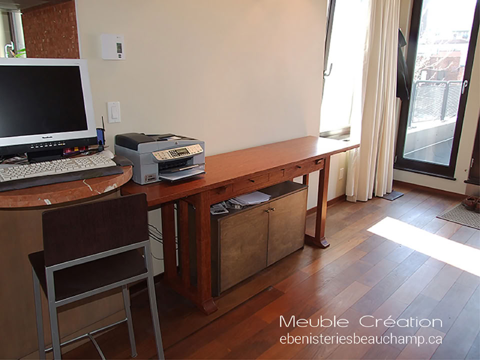 Un bureau avec un ordinateur, une imprimante, une chaise et une grande fenêtre avec des rideaux.