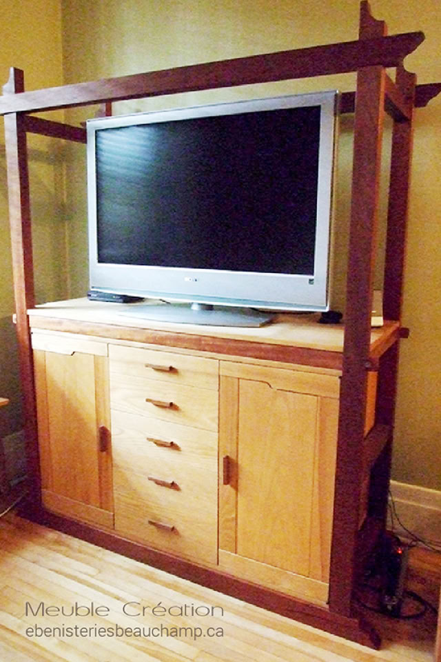 Meuble en bois avec une télévision à écran plat posée dessus, comportant plusieurs tiroirs et portes.