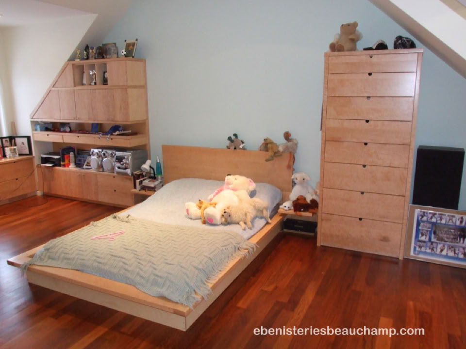 Chambre avec un lit simple, des étagères en bois, des peluches sur le lit, et un parquet en bois.