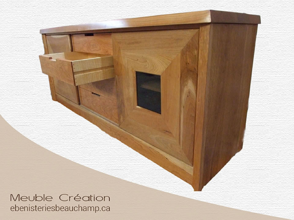 Buffet en bois avec deux tiroirs ouverts et une porte vitrée, sur un fond blanc avec texte en bas à gauche.